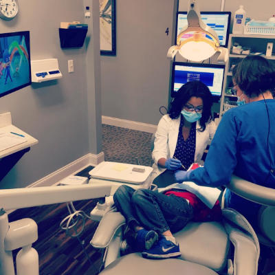 Antoinette Liles, DMD and her dental assistant performing pediatric dental treatment.